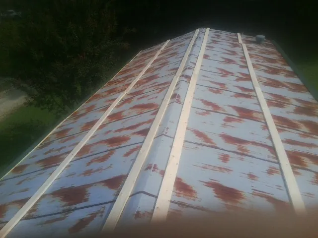 Rusted metal roof panels with new wood purlins before replacement — Storm Damage Roof Repair in Liberty by Roofing Brothers